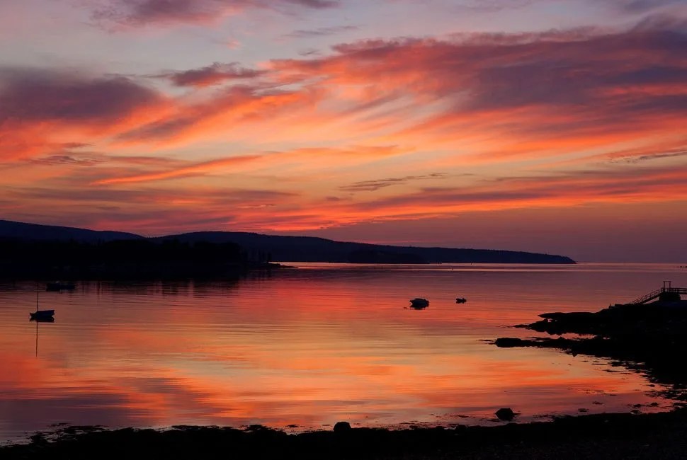 The rising sun bathes a harbor in Acadia National Park