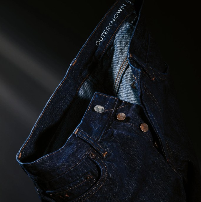 a hanging pair of outerknown denim jeans