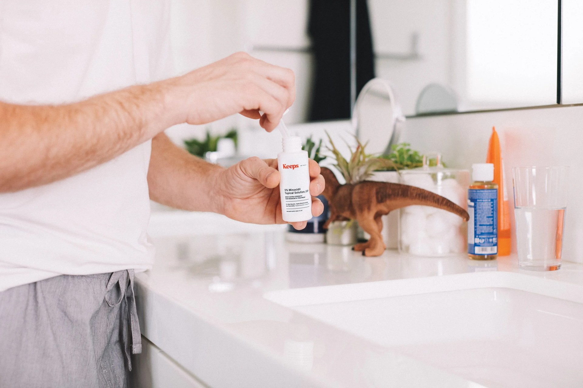 man unscrewing the top of a keeps grooming product