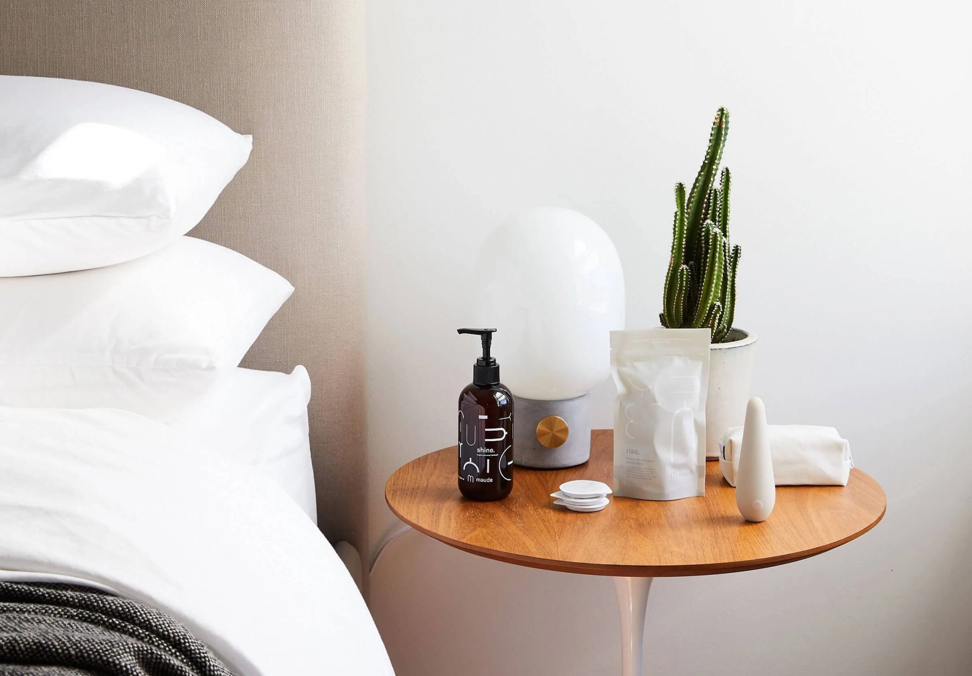 maude grooming products sitting on a bedside table