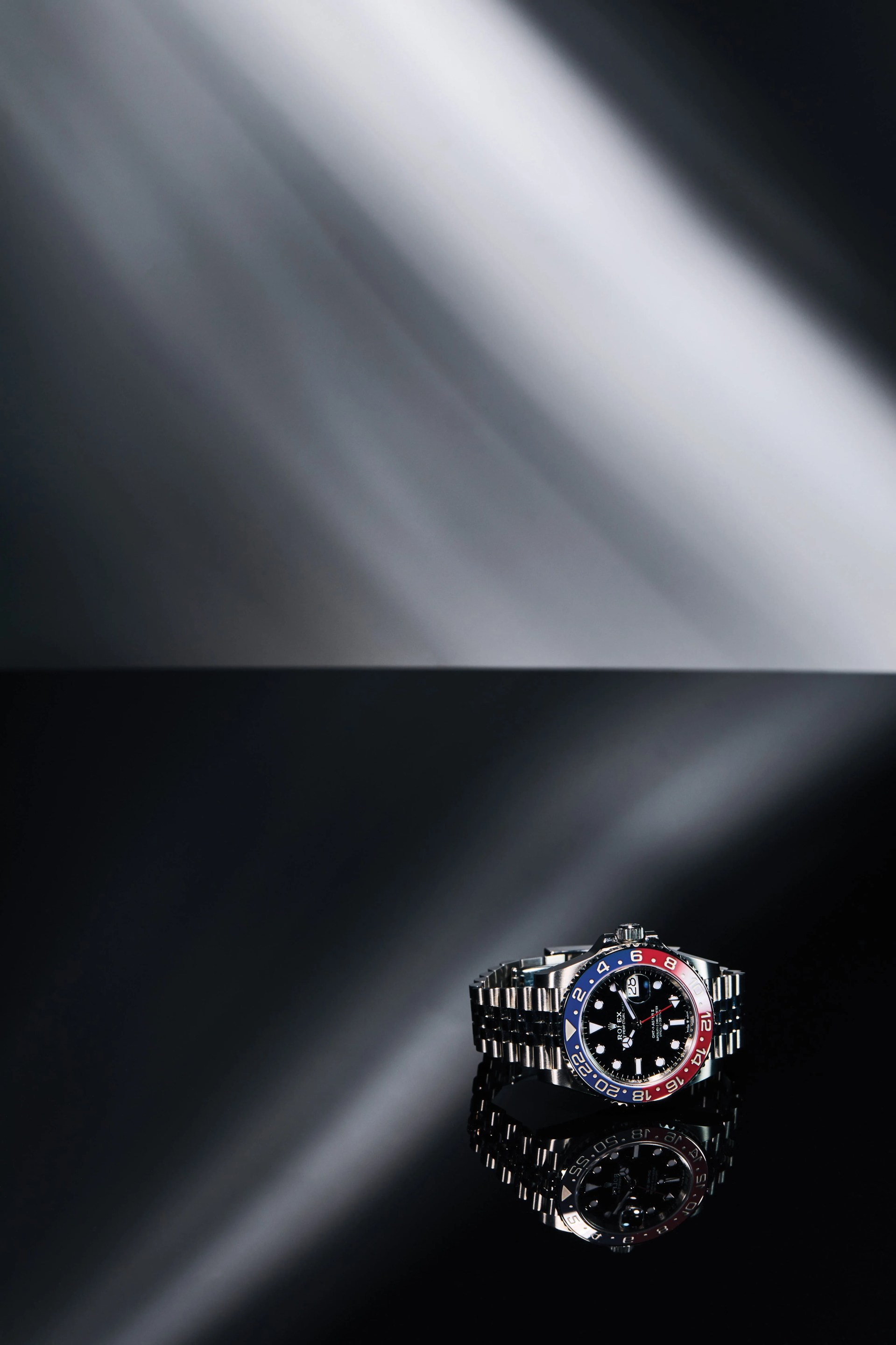 rolex gmt pepsi bezel watch with a silver bracelet