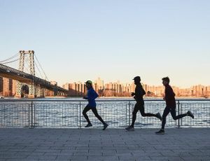 group of people running in front of a sunset