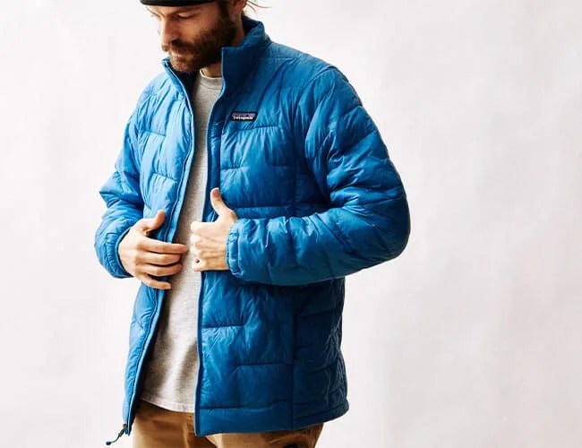 a man wearing a blue patagonia puffy jacket on a blank background