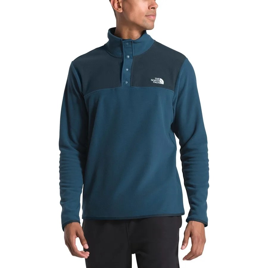 blue snap up The North Face fleece on a model with black pants and on a white background.