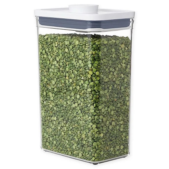 A clear OXO rectangular container filled with lentils on a white background.
