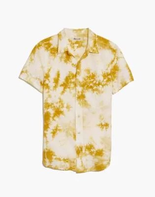 A gold tie dye button up short sleeve shirt on a white background.