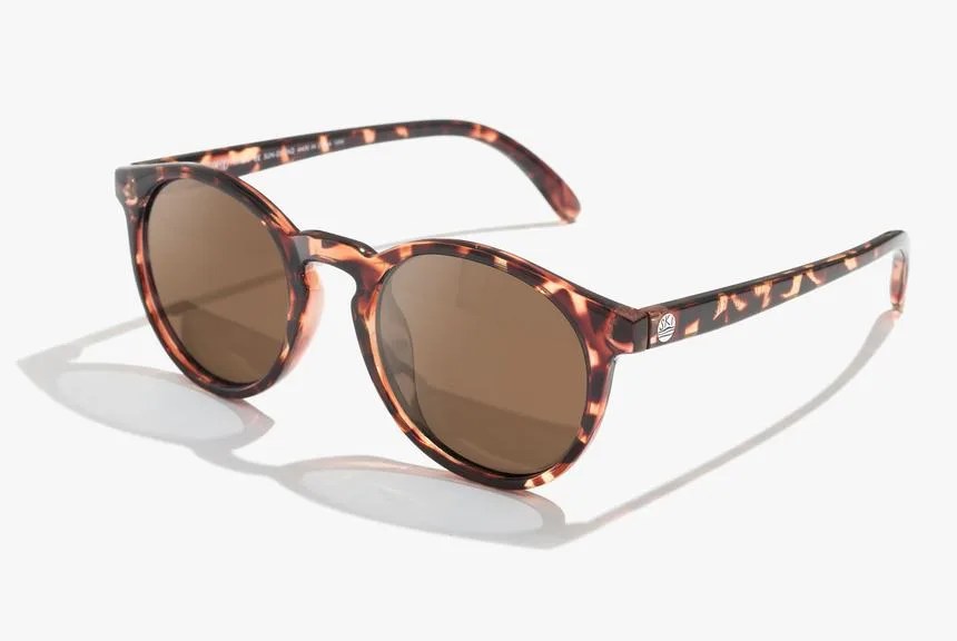 Round frame sunglasses in tortoise color with amber color lenses on a white background.