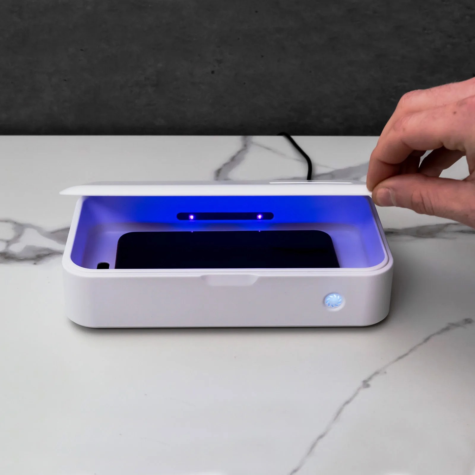 A UV blue light sterilizing pod for gadgets on a gray background.