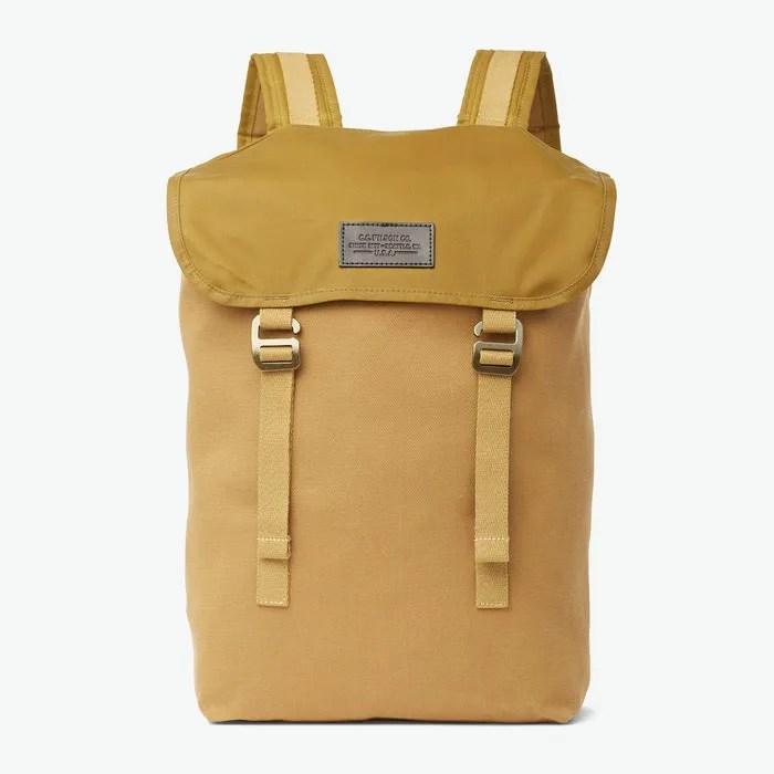 A tan backpack on a gray background.