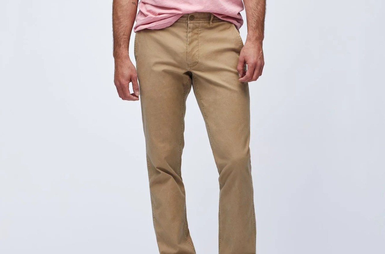 khaki chinos on a model with a gray t shirt and white sneakers on a gray background