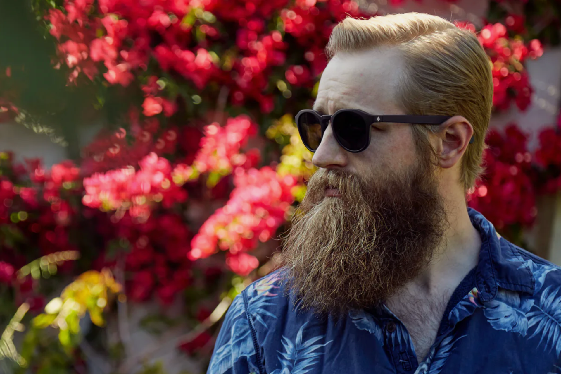 a model wearing a hawaiian shirt with a beard and sunglasses