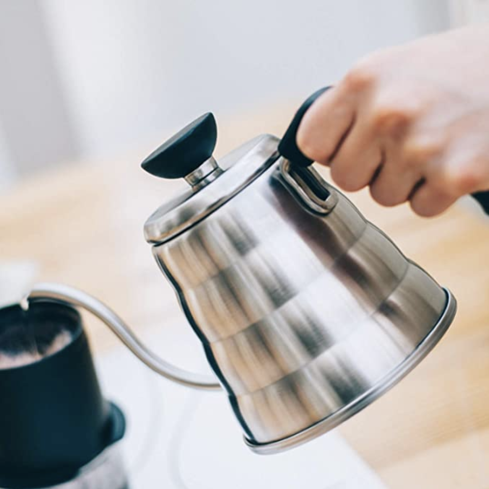 a stainless steel kettle being poured into a mug