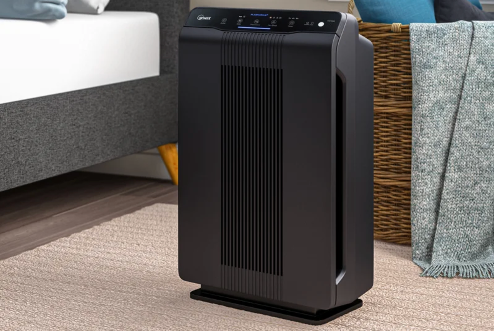 a black air purifier in a bedroom scene