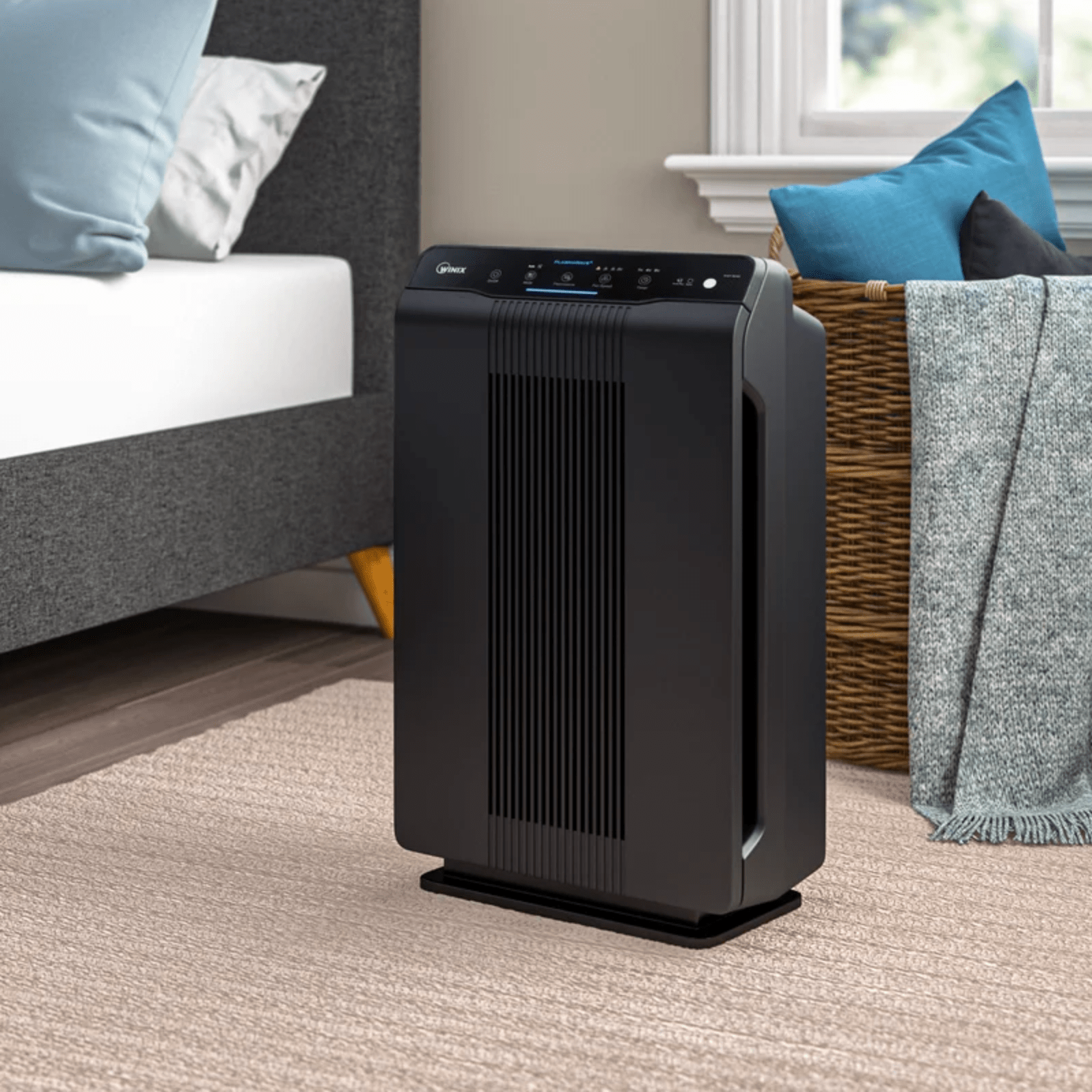 a black air purifier in a bedroom scene