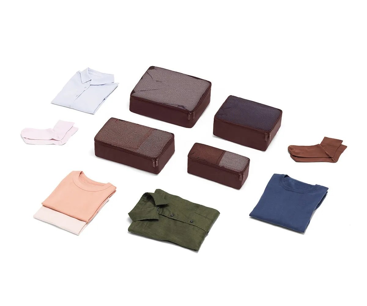 Packing cubes and garments folded on a gray background.