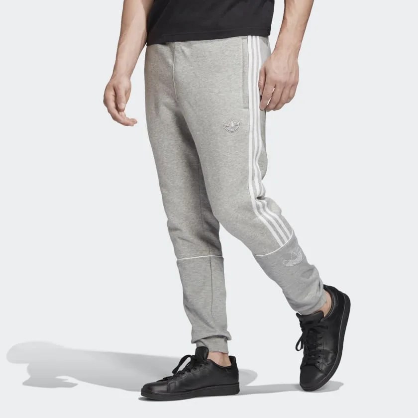A model wearing gray sweatpants and black sneakers.