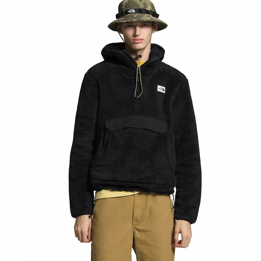 A model wearing a black hooded fleece and camo bucket hat