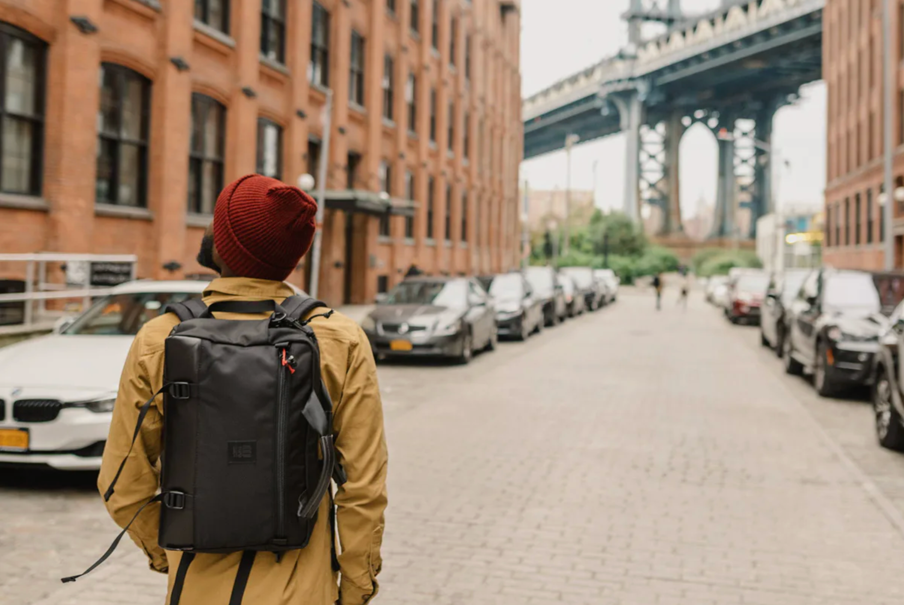 a model walking down a street in brooklyn towards the manhattan bridge