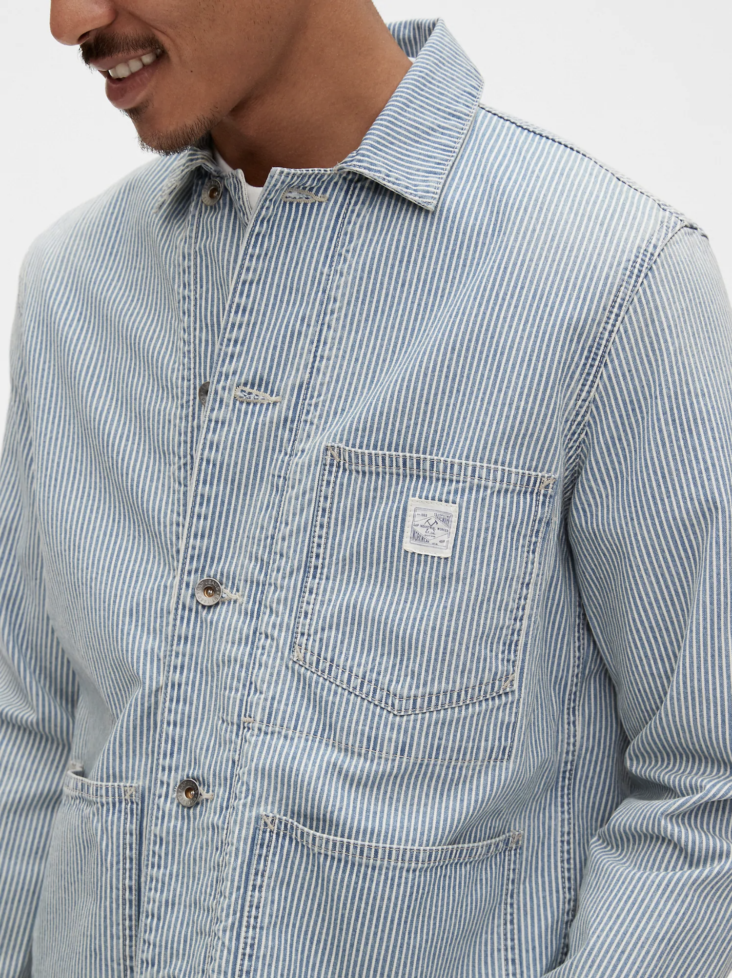 a model wearing a blue railroad stripe chore jacket