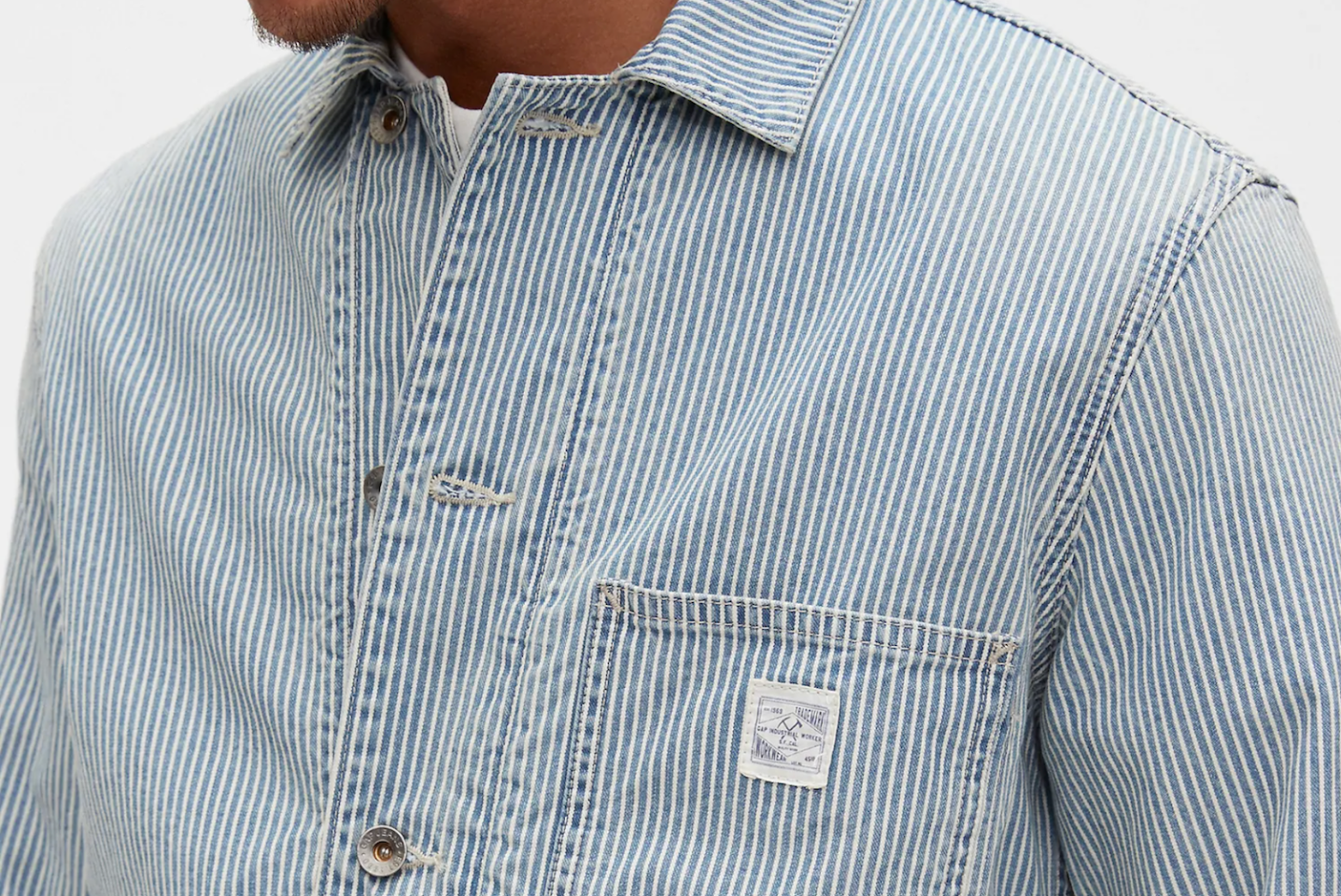 a model wearing a blue railroad stripe chore jacket