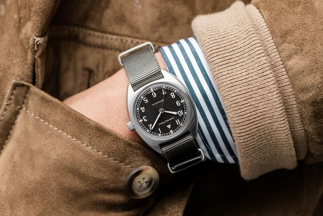 vintage style watch on wrist with leather coat