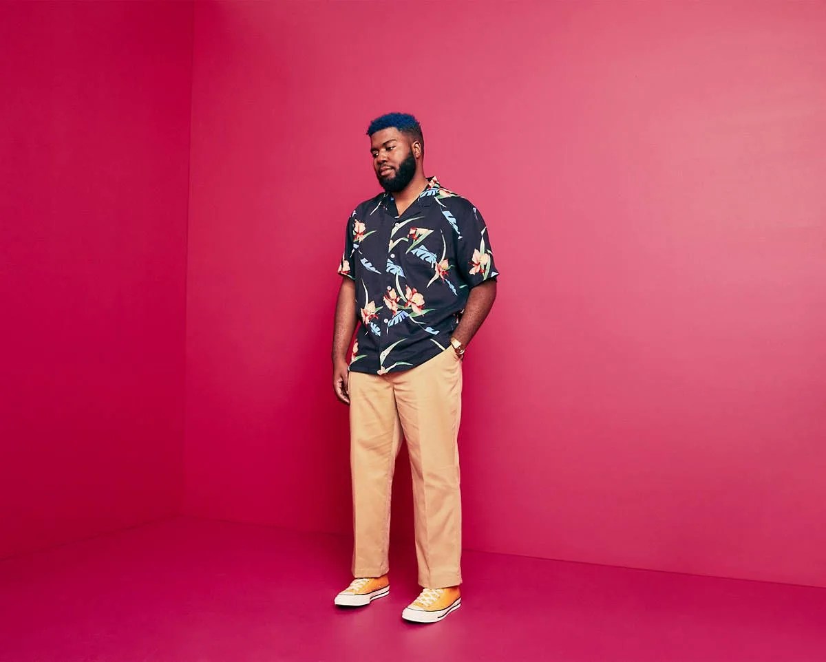 man wearing hawaiian shirt, khakis and yellow sneakers