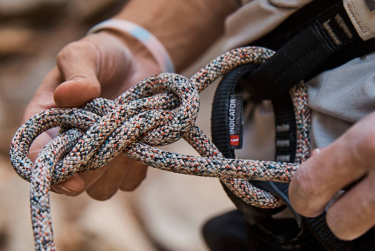 a man tying a colorful climbing rope