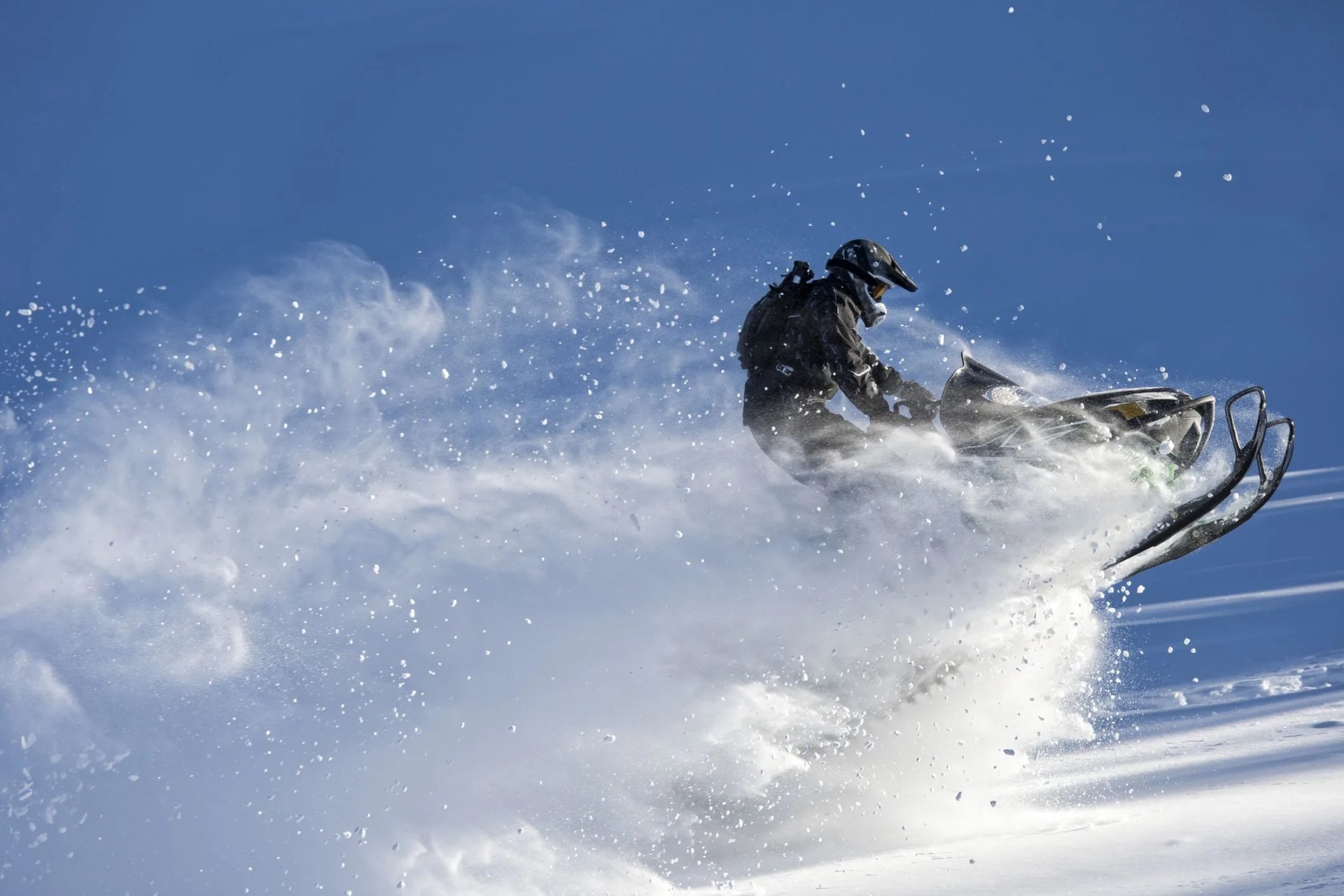 snowmobile jumping in the powder