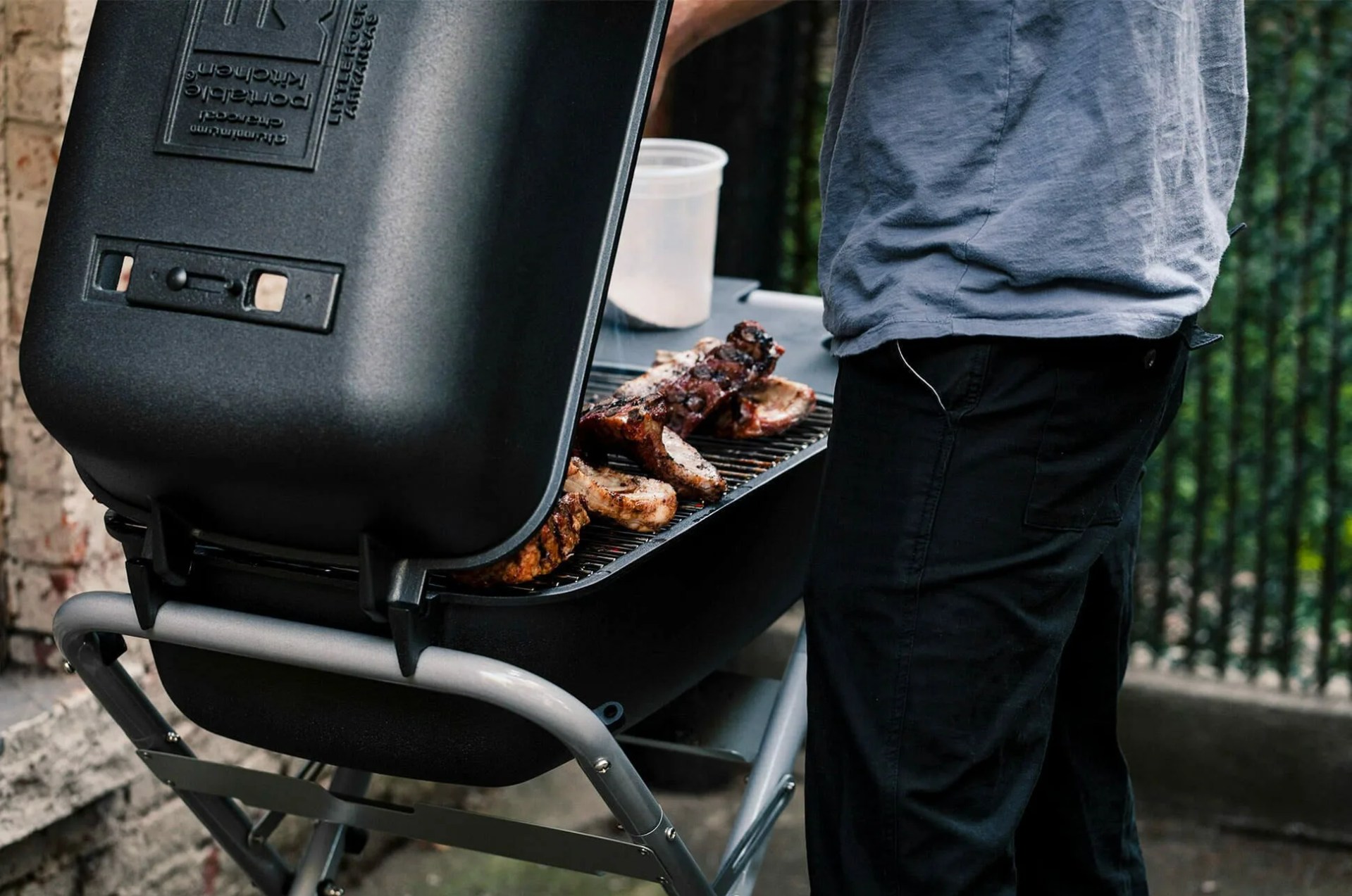 man cooking on a charcoal grll