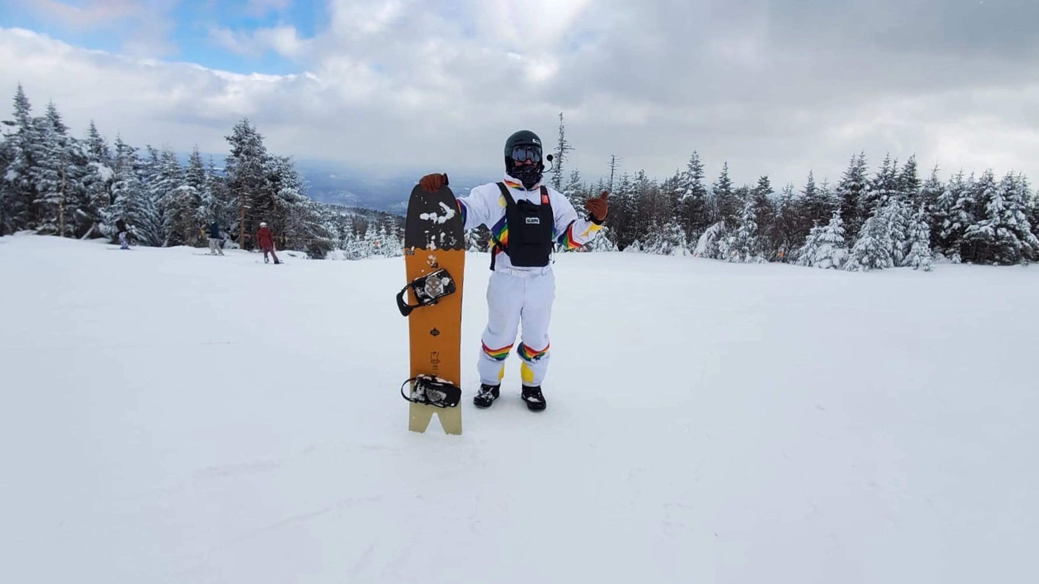 man holding snowboard on snowy mountain