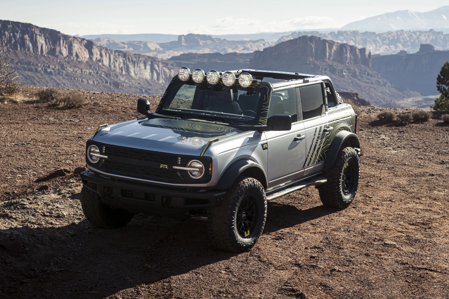 this multipurpose heavy duty bronco four door badlands suv by rtr vehicles sports custom rtr rock sliders and rear bumper, rtr 3d printed grille with simulated accent lights, plus 35 inch nitto ridge grappler tires mounted to rtr tech 6 wheels a roof mounted project x lightbar, custom rtr graphics and 12 volt type s blizzard box refrigeratorfreezer in back complete the package