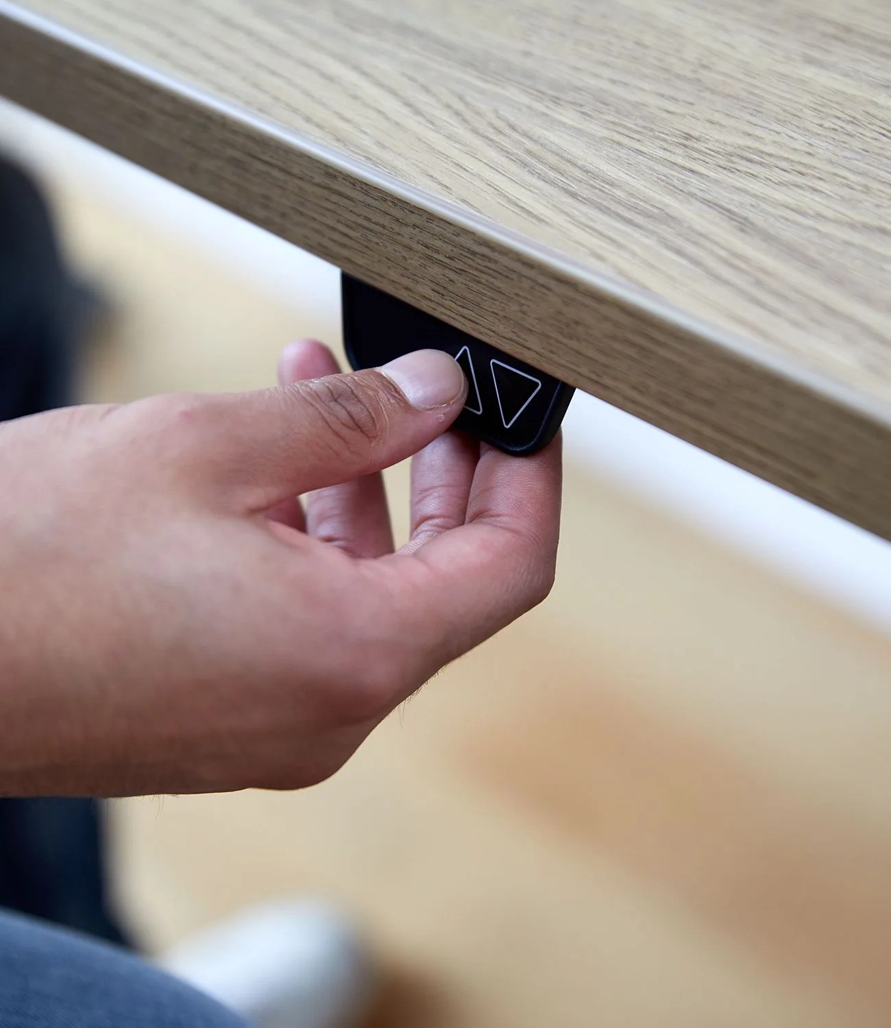 hand pulling at tab of knolls standing desk