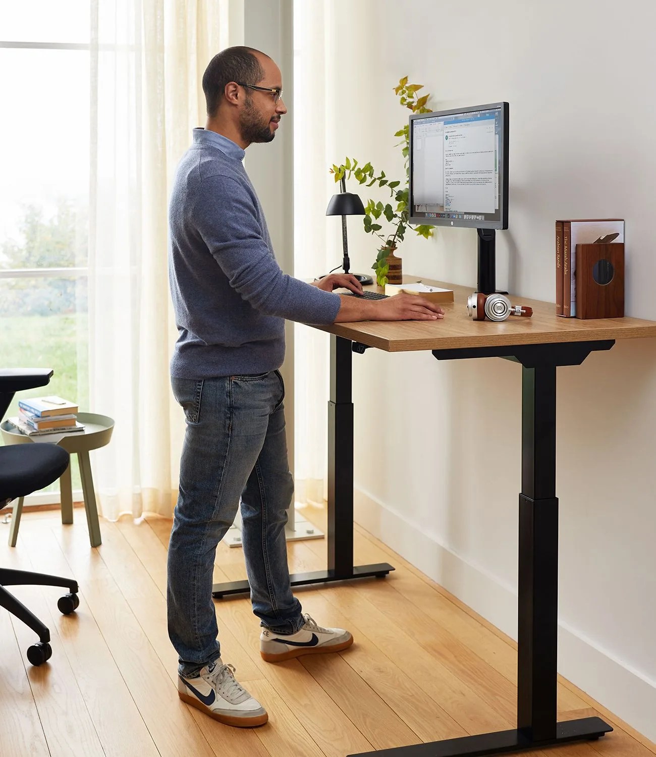 man standing at his knoll desk