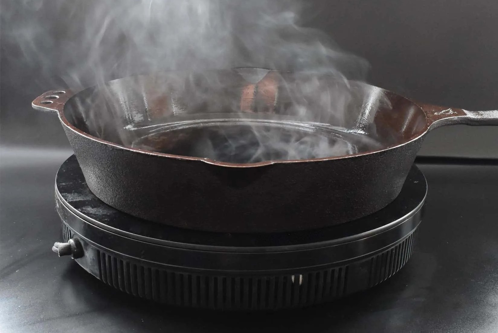 a cast iron skillet smoking on a hot plate