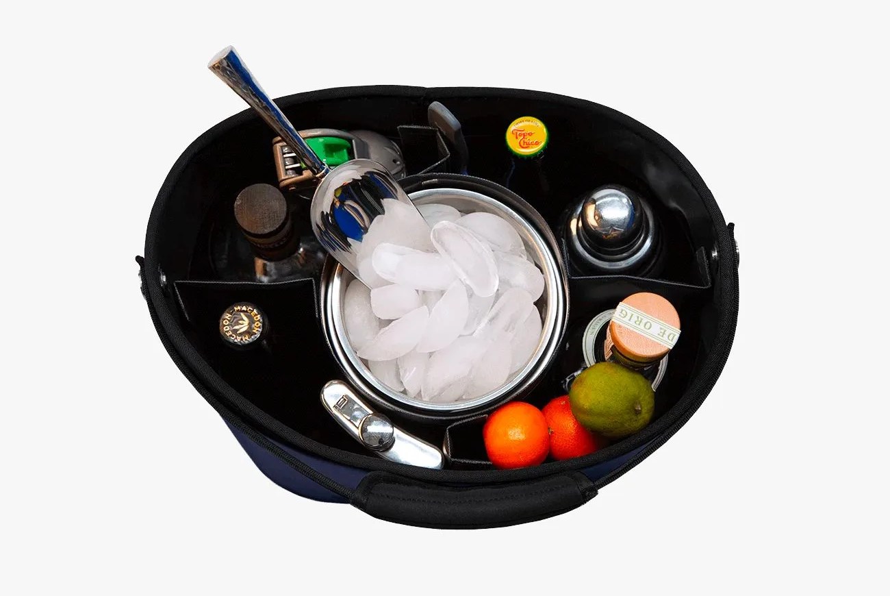 an overhead view of a picnic bucket filled with ice, bottles and snacks