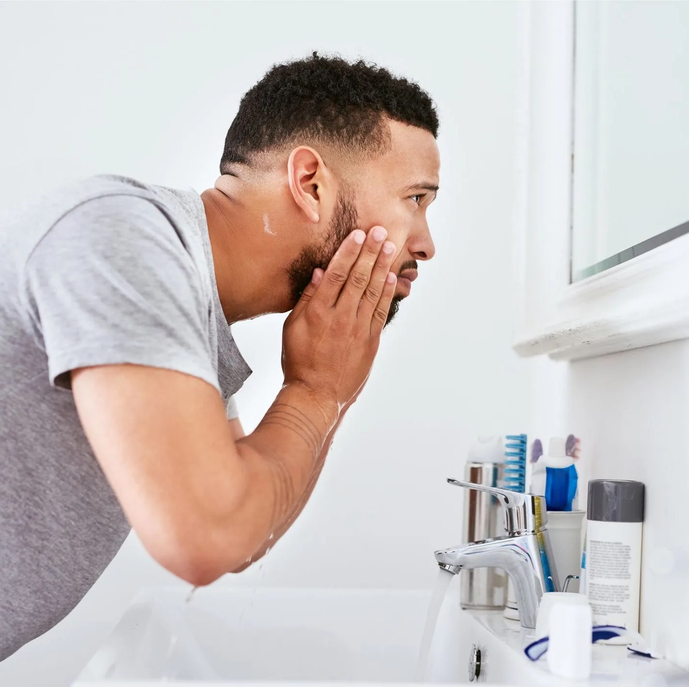 man examining face in mirror