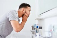 man examining face in mirror