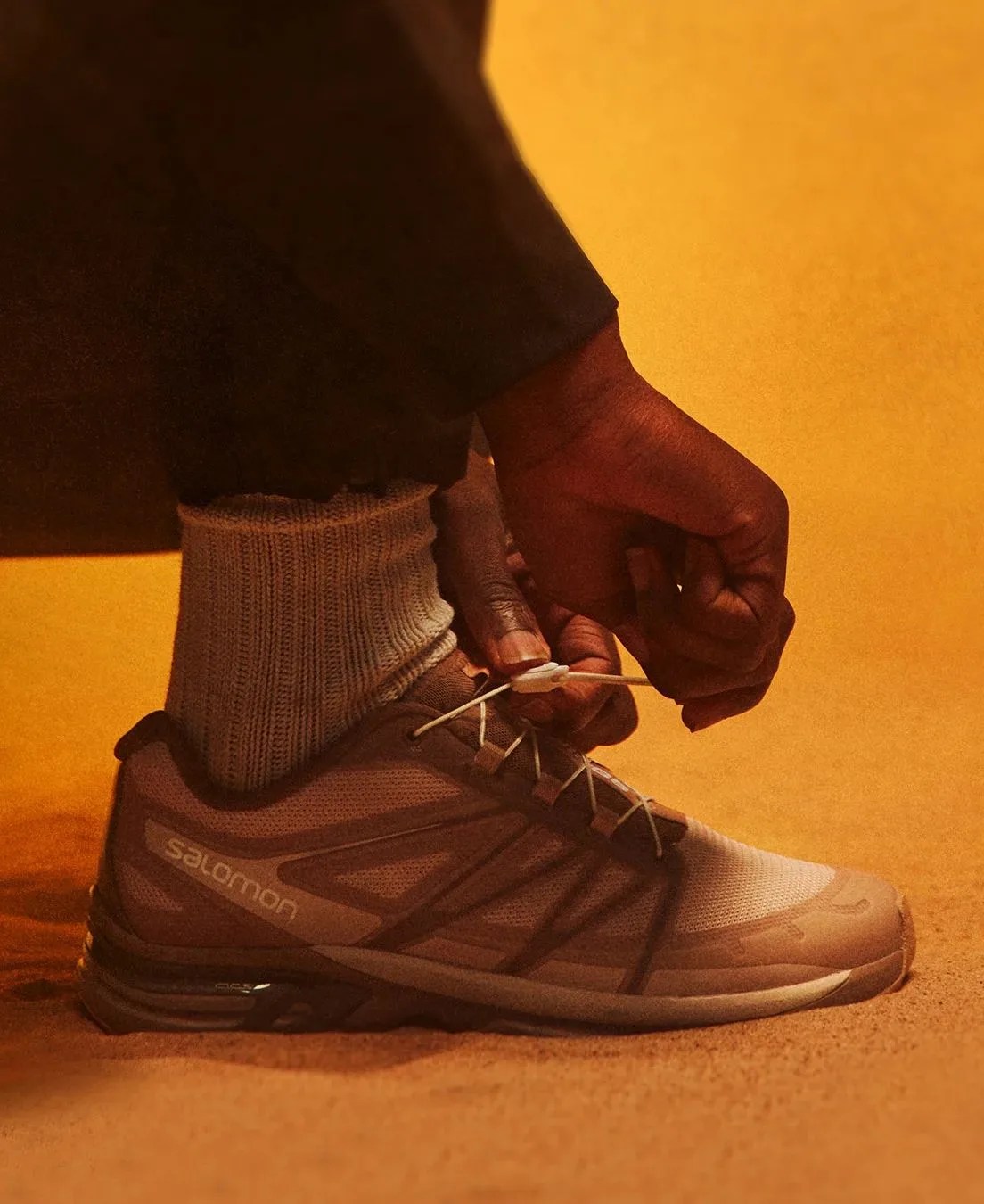 person tying salomon shoe