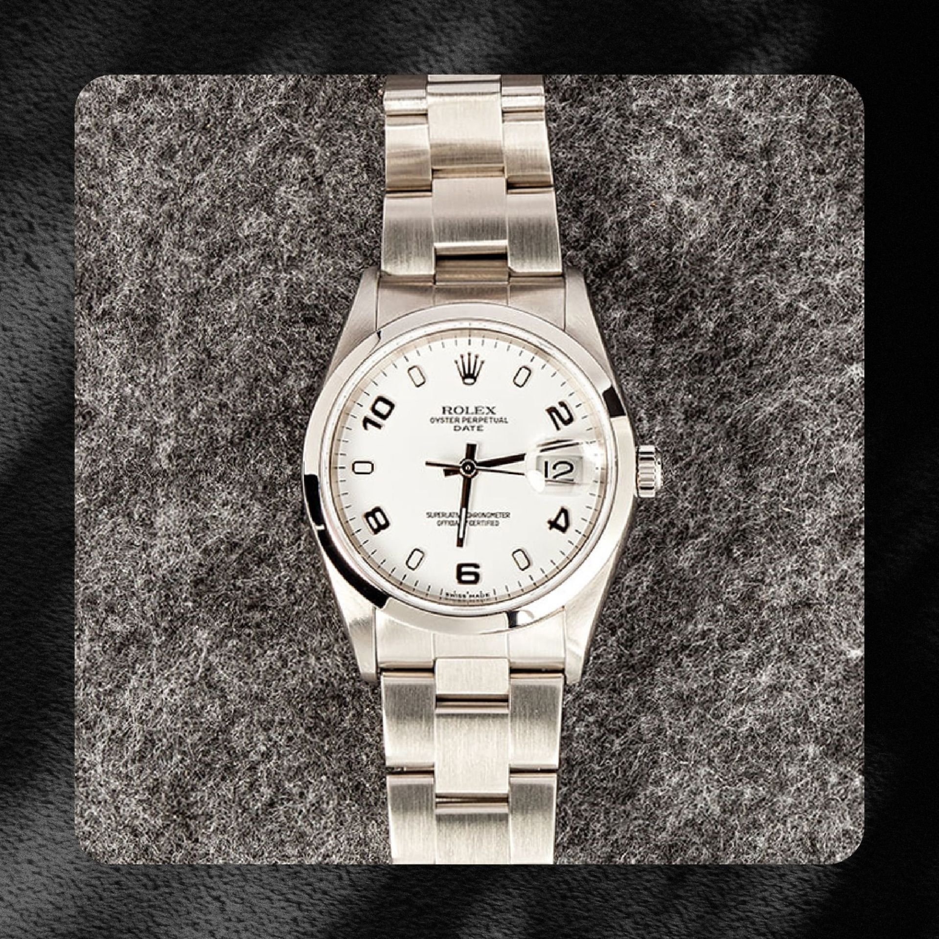 silver rolex oyster watch against dark grey carpet