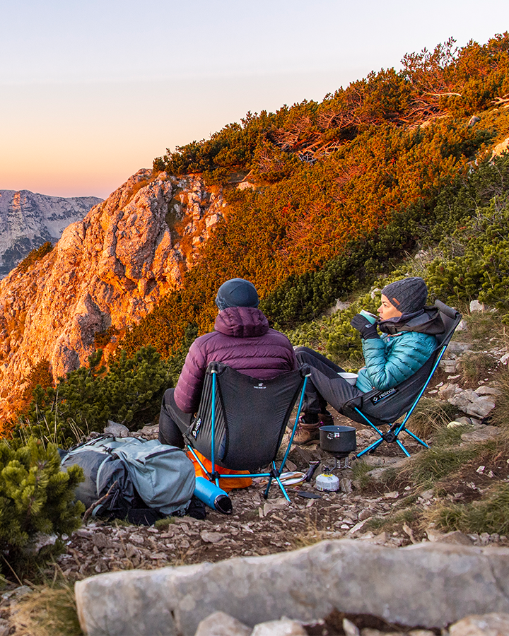 two people sitting on helinox ultralight chair zero high back on mountainside