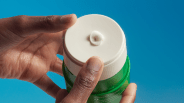 two hands squeezing lotion out of humanscale bottle