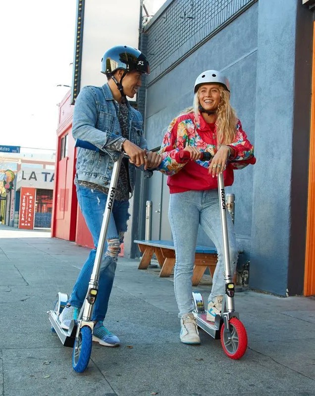 man and woman on razor scooter