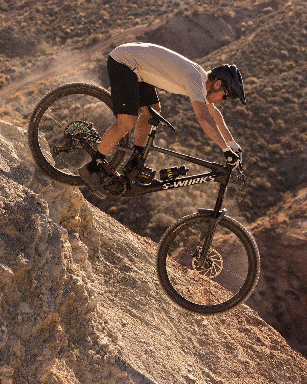 man riding down rocky terrain on s works bike wearing specialized ambush helmet