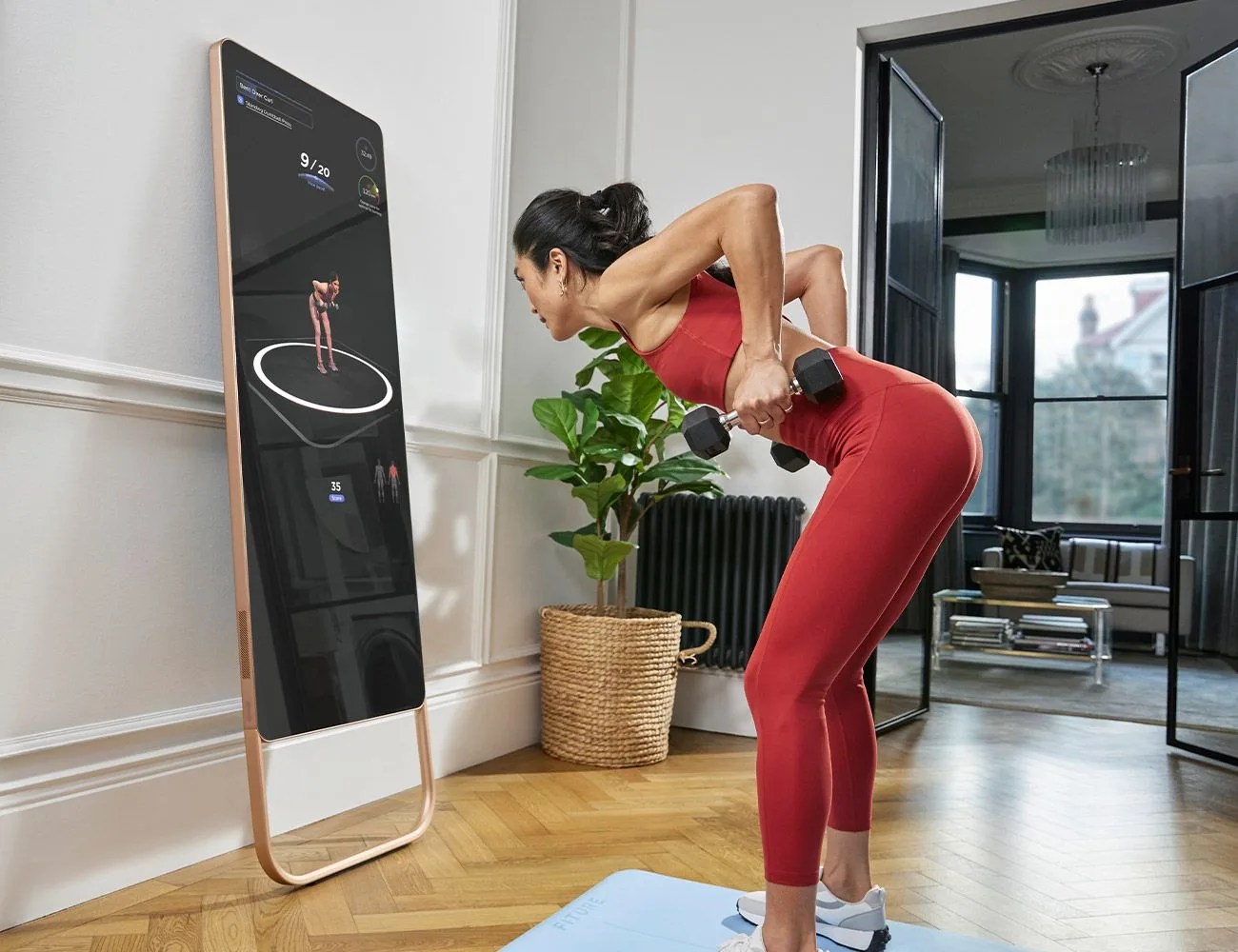 a woman using fiture interactive smart fitness mirror