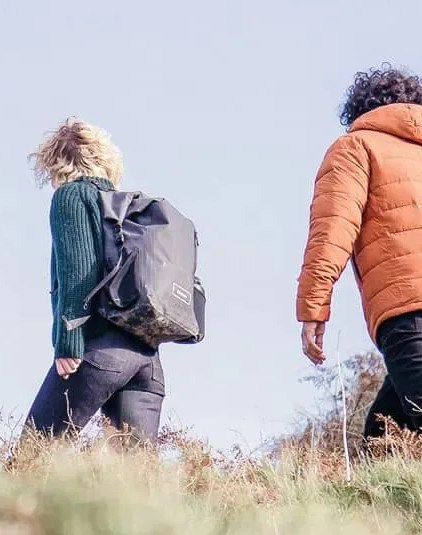 two people walking through hillside wearing finisterre x reskinned clothing