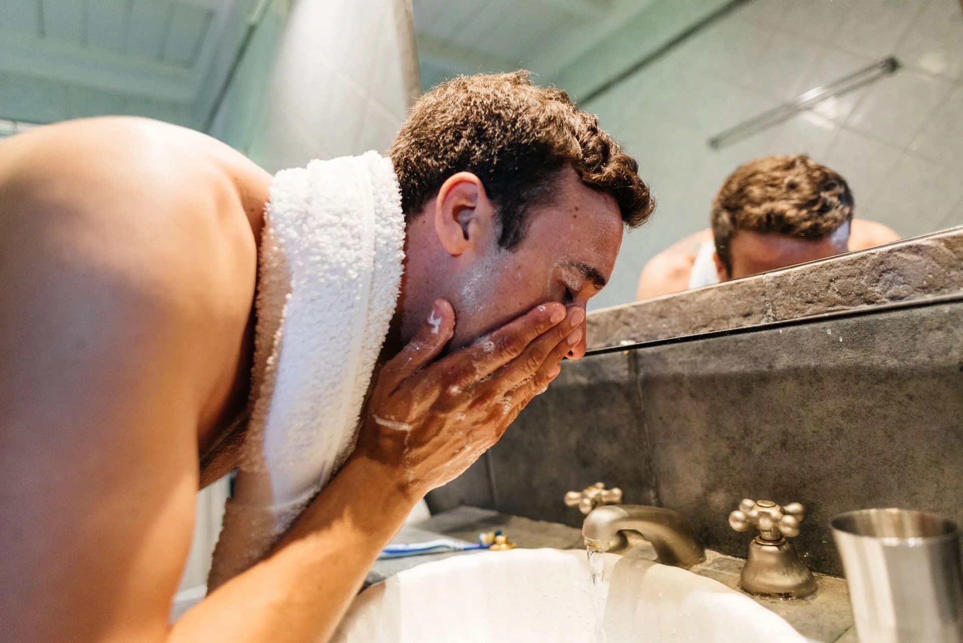 man washing his face in the bathroom