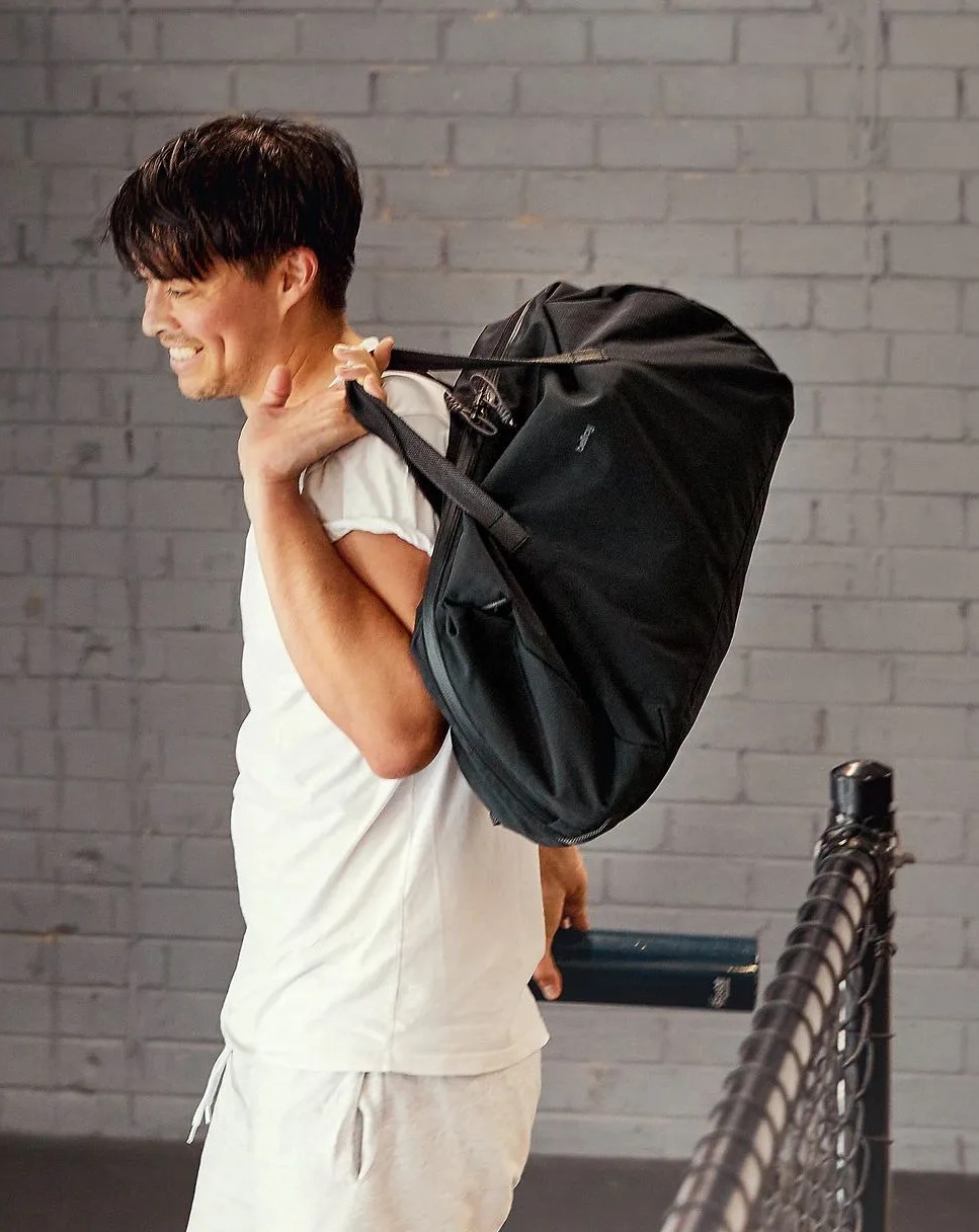 man holding bellroy venture duffel 40l over shoulder