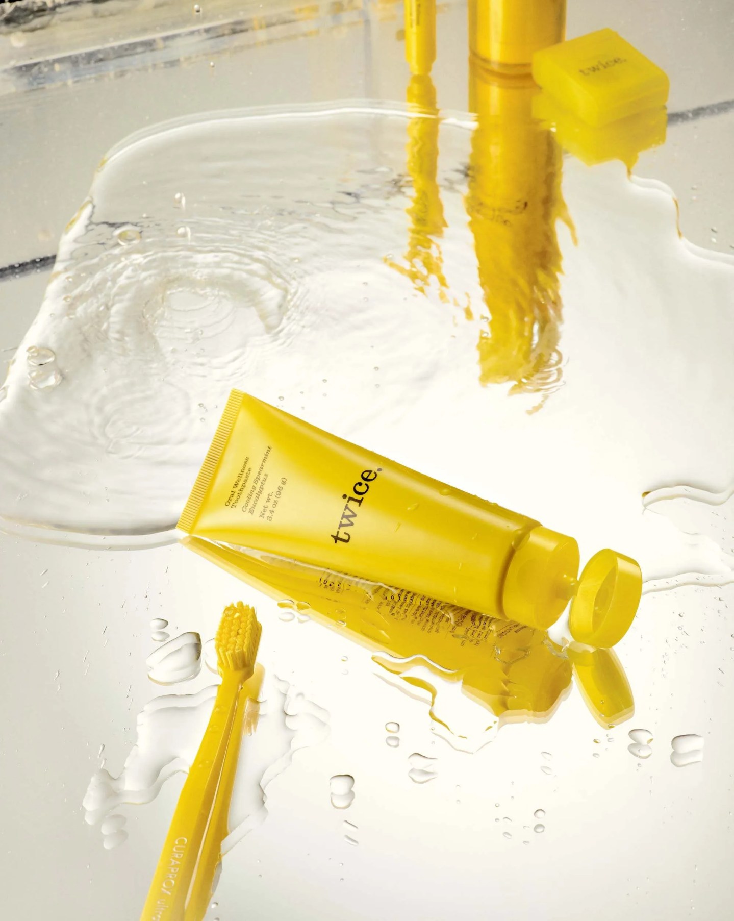 twice toothpaste on a table with a toothbrush