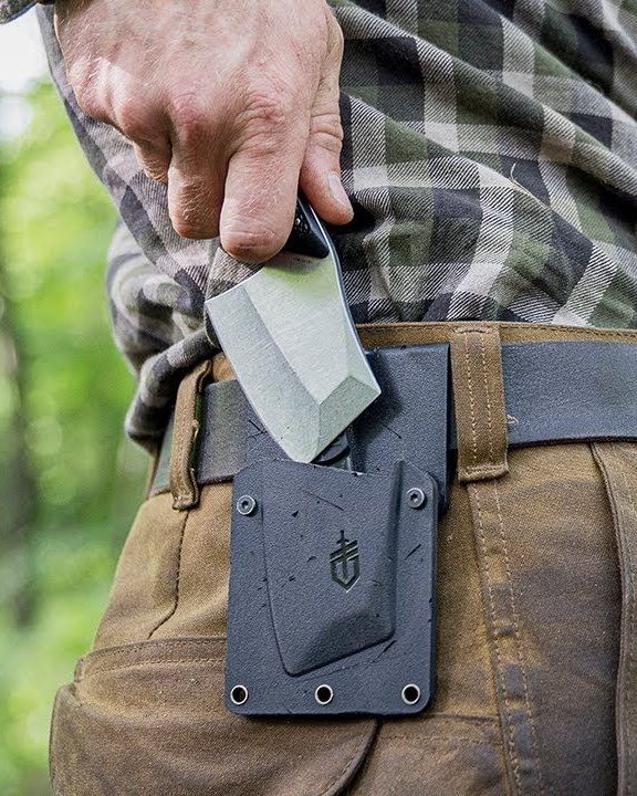 man taking gerber tri tip mini cleaver out of sheathe