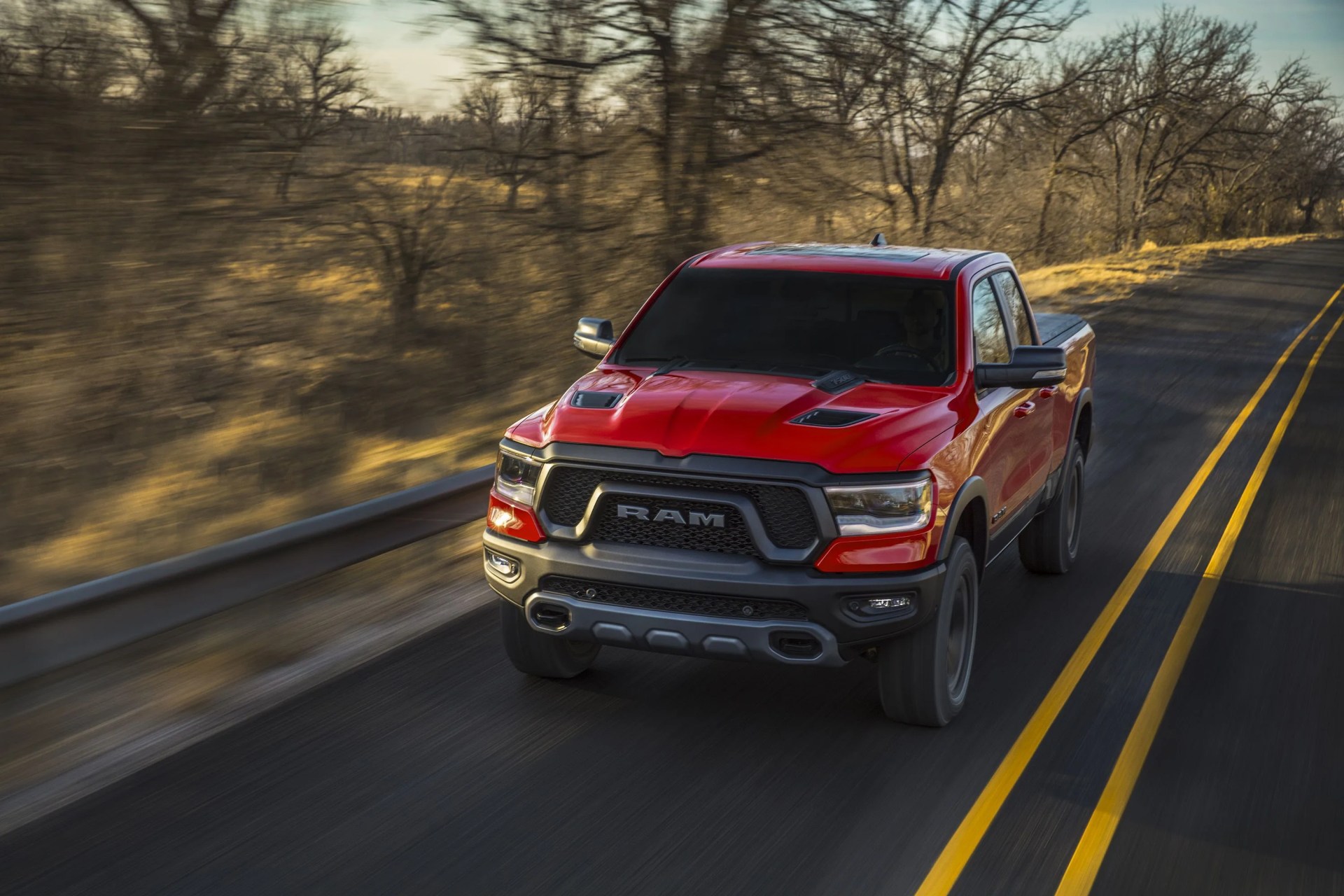 2022 ram 1500 rebel driving on a two lane highway with trees in the background
